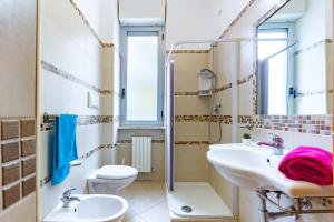 een badkamer met een wastafel, een toilet en een douche bij Appartamento Pinolo Bilo INT 4 - MyHo Casa in Alba Adriatica