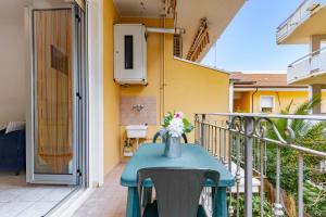 een tafel op een balkon met een vaas met bloemen bij Appartamento Pinolo Bilo INT 4 - MyHo Casa in Alba Adriatica