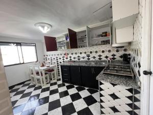 a kitchen with a black and white checkered floor at Casa Marwan in Tétouan