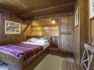 um quarto com uma cama num chalé de madeira em Chalet La Clusaz, 5 pièces, 8 personnes - FR-1-304-108 em La Clusaz