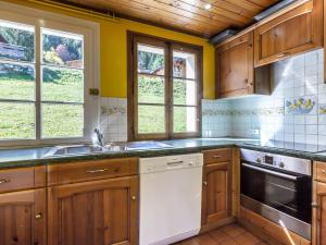 cocina con armarios de madera y lavavajillas blanco en Chalet proche pistes, cheminée, garage, Wifi - FR-1-304-108, en La Clusaz