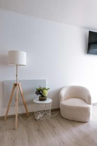 een woonkamer met een stoel en een lamp bij Cosy studio near the beach in Oostende