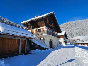 une maison dans la neige avec une route devant dans l'établissement Chalet La Clusaz, 5 pièces, 8 personnes - FR-1-304-108, à La Clusaz