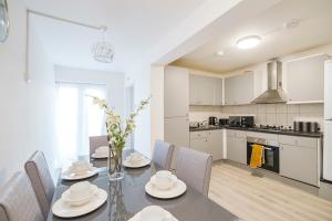 a kitchen and dining room with a table and chairs at Heads-On-Beds Rainham Essex - 4Bedrooms with Garden in Rainham