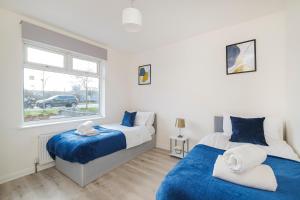 2 camas en un dormitorio con ventana en Heads-On-Beds Rainham Essex - 4Bedrooms with Garden, en Rainham