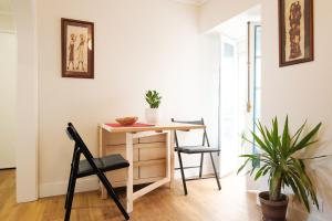a desk and chairs in a room with a plant at Casa do Sr. Elias in Sesimbra