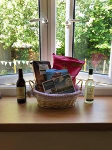 a basket of books and wine bottles on a window sill at 2 bedroom Holiday home in Norfolk private field in Wisbech