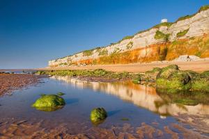 a beach with some rocks in the water at 2 bedroom Holiday home in Norfolk private field in Wisbech