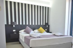 a bedroom with a large bed with colorful pillows at Galini Sea View Hotel in Agia Marina Nea Kydonias