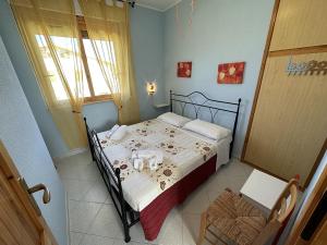 1 dormitorio con cama y ventana en Appartamento a 50 metri dal mare a Maladroxia C36 en Maladroscia