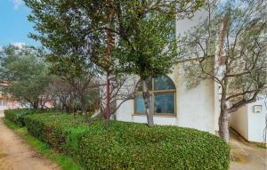 a house with a hedge in front of a building at 2 Bedroom Cozy Apartment In Fazana in Fažana