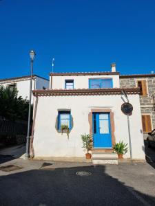 a white house with a blue door on a street at A casa di Pietro 