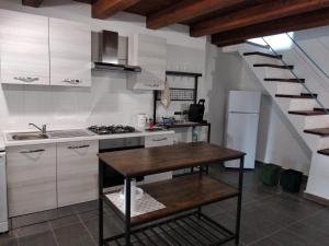 uma cozinha com uma mesa e uma cozinha com uma escada em A casa di Pietro 