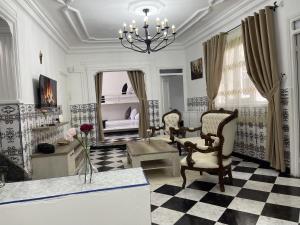 a living room with a chandelier and a chair and a bedroom at Casa Marwan in Tétouan
