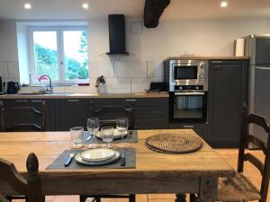eine Küche mit einem Holztisch mit einem Teller darauf in der Unterkunft Cottage de Vittefleur in Vittefleur