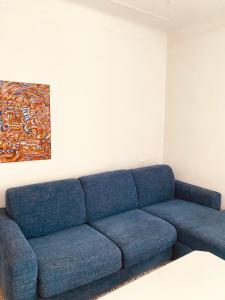 eine blaue Couch in einem Wohnzimmer mit einem Gemälde in der Unterkunft ‘’Perla Marina’‘ in Levanto