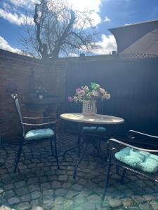 a table and chairs with a vase of flowers on a patio at Priscilla’s bed&wellness in Eindhoven