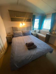 - une chambre avec un lit et une serviette dans l'établissement Impeccable 2-Bed Lodge in Ashington, à Ashington