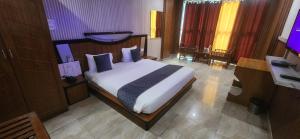 sypialnia z łóżkiem z białą pościelą i niebieskimi poduszkami w obiekcie Chopra Residency w mieście Hamīrpur