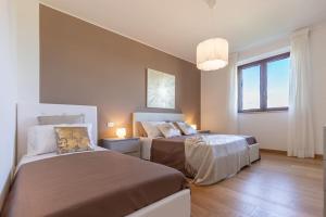 een slaapkamer met 2 bedden en een groot raam bij [Villa Luxury] Piscina BBQ Free Parking in Capodarco