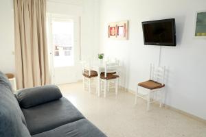 uma sala de estar com um sofá e uma mesa com cadeiras em Apartamento Luna Llena Golf de San Juan de los Terreros em San Juan de los Terreros