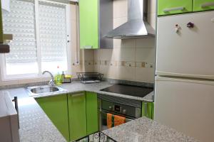 uma cozinha com armários verdes e um frigorífico branco em Apartamento Luna Llena Golf de San Juan de los Terreros em San Juan de los Terreros