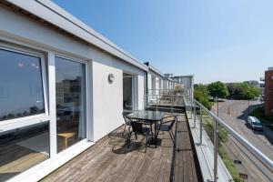 a balcony with a table and chairs on a building at Modern 2 Bed Apartment in Crawley - Sleeps 5 in Crawley