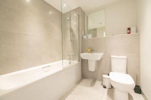 a white bathroom with a toilet and a sink at Modern 2 Bed Apartment in Crawley - Sleeps 5 in Crawley