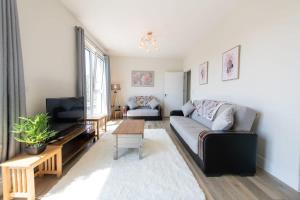 ein Wohnzimmer mit einem Sofa und einem TV in der Unterkunft Modern 2 Bed Apartment in Crawley - Sleeps 5 in Crawley