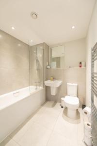 a white bathroom with a toilet and a sink at Modern 2 Bed Apartment in Crawley - Sleeps 5 in Crawley