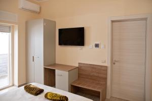 a bedroom with a bed and a television on the wall at Mary Lucy in Porto Cesareo