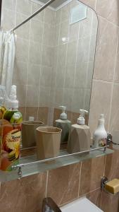 a bathroom shelf with toiletries on it in front of a mirror at Апартаменты посуточно in Atyrau