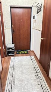 a hallway with a door with a rug in front of it at Апартаменты посуточно in Atyrau