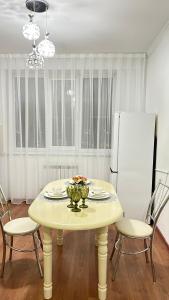 a dining room table with chairs and a white refrigerator at Апартаменты посуточно in Atyrau