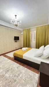 sypialnia z dużym łóżkiem i żyrandolem w obiekcie Апартаменты посуточно w mieście Atyrau