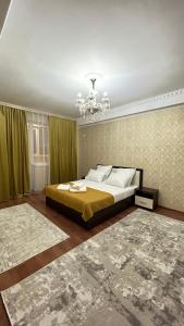 sypialnia z łóżkiem i żyrandolem w obiekcie Апартаменты посуточно w mieście Atyrau