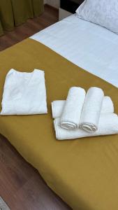 a bed with white towels on a yellow blanket at Апартаменты посуточно in Atyrau