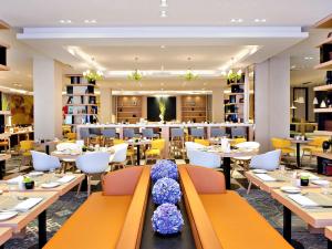 a restaurant with tables and chairs and a library at Sofitel Warsaw Victoria in Warsaw