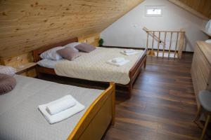 2 łóżka w pokoju z drewnianą podłogą i schodami w obiekcie Medeni raj w mieście Mače