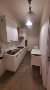 a small kitchen with white cabinets and a sink at Bergamo Centro Residence in Bergamo