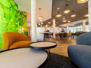 a lobby with chairs and a table and a tableasteryasteryasteryasteryasteryastery at ibis Styles Troyes Centre in Troyes