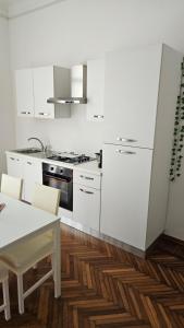 a kitchen with white appliances and a table and chairs at Appartamenti Fiore in Sanremo