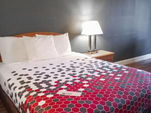 a bed in a hotel room with a colorful comforter at Econo Lodge in Maquoketa