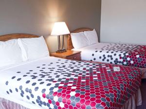 a hotel room with two beds and a lamp at Econo Lodge in Maquoketa