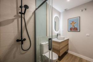 La salle de bains est pourvue d'une douche, de toilettes et d'un lavabo. dans l'établissement Luxe Apartment in Malasaña Hub, à Madrid