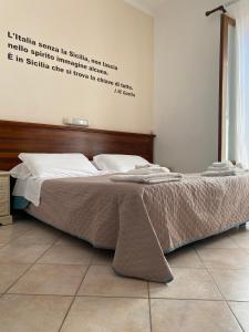 a large bed in a bedroom with words on the wall at Mamamia Lipari in Lipari