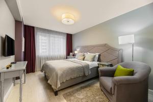 a bedroom with a bed and a chair at ARA Apart Hotel #2 in Braşov