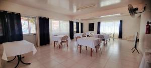 a dining room with white tables and chairs at OpenSky in São Filipe