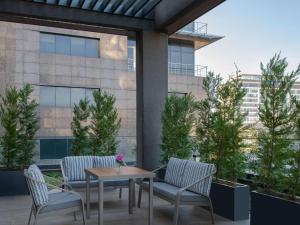 a patio with a table and chairs and a building at Movenpick Living Istanbul West in Istanbul