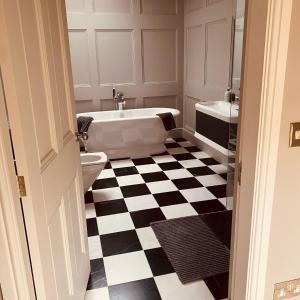 a bathroom with a black and white checkered floor at The Stable's Barn in Bigby in Barnetby le Wold